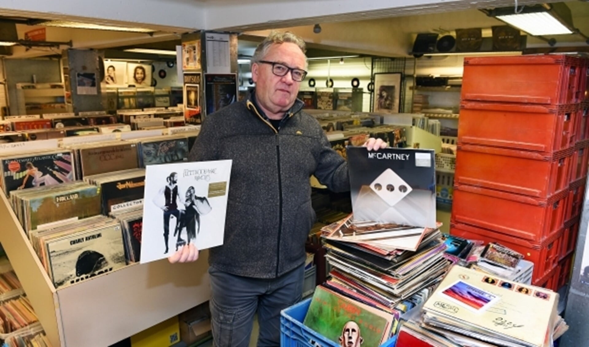 Wim Vriezen heeft het album 'Rumours' van Fleetwood Mac in handen, die hij nog wekelijks verkoopt, en de nieuwe LP van Mc Carteney. (foto: Roel Kleinpenning)