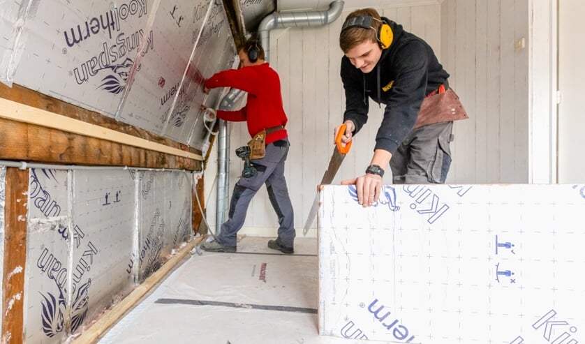 Foto: Medewerkers van aannemersbedrijf Kormelink brengen isolatiemateriaal aan tijdens de verduurzaming van een leegstaande woning. Foto: Nicole Tanke, Lines Are Everywhere