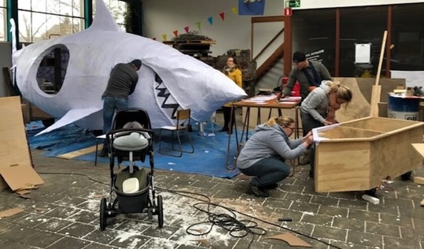 Leden van Groep Hertenkamp aan het werk met hun carnavalswagen.