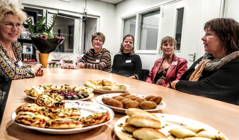Hapjes ter ere van de opening van het nieuwe kantoor van Vluchtelingenwerk Bronckhorst. Links vrijwilligster Dineke Pelgrom, aan de overkant v.l.n.r. Daniëlle Hakvoort, Delia Römer, Karen van Kan (teamleider) en Liselore Geurts. Op de foto ontbreekt Rob Pastoor. Foto: Luuk Stam