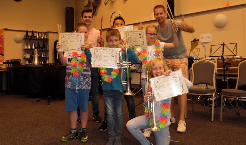 Oud-leerlingen muziek maak je zelf met hun behaalde diploma's en docenten Mart Ebbers en Bas Konings. Foto PR