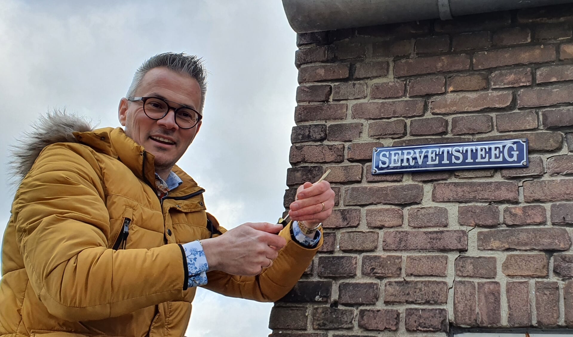 Peter Nieuwenhuis van de Hisvebo brengt het bordje Servetsteeg aan. Foto: Rob Weeber
