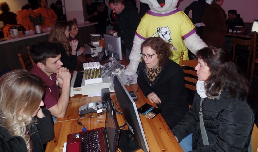 Anja Bikkel en Marieke ten Dolle (rechts) waren met Rinus Tragter (achtergrond) onder toeziend oog van de Reurpop mascotte Rupo de eerste kaartkopers tijdens de Nachtoele actie. Foto: Jan Hendriksen