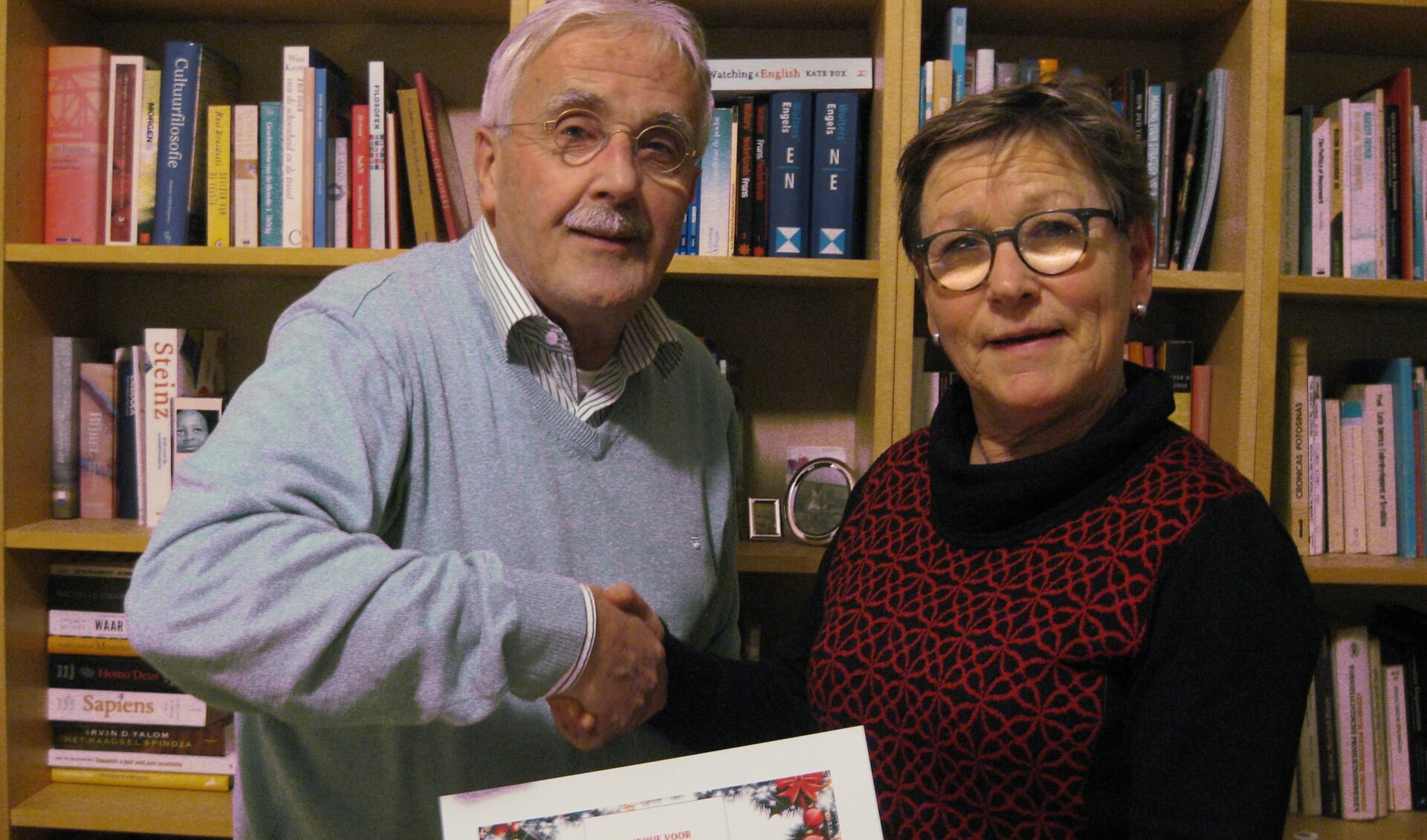 Hennie Vink, fondsenwerver en lid van de projectgroep Kerst-Inn 2019 van KunstKring Ruurlo overhandigt de cheque aan Wout Kranendonk, penningmeester van de Protestantse Gemeente Ruurlo-Barchem. Foto: PR. 