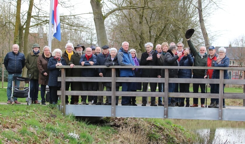 Belangstellenden proosten bij de brug over de Baakse Beek in Vorden, waar verlichting is aangebracht. Foto: Rob Schmitz