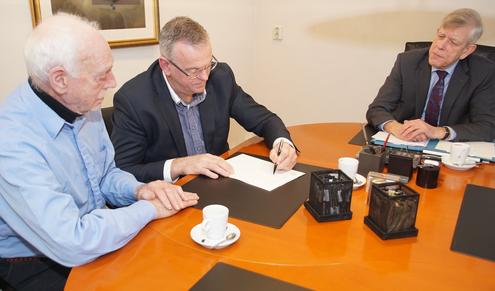 Onder toeziend oog van notaris Moerland (rechts) ondertekenen Leo Gensen en Jan Steverink (midden) de akte met de statuten. Foto: Frank Vinkenvleugel