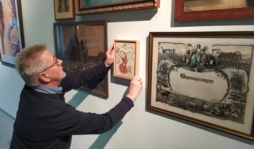 Bert van Ek bezig met inrichten van de expositie Kunst uit de Kamer. Foto: PR