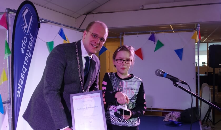 Naomi krijgt een onderscheiding en een kettinkje. Foto: Clemens Bielen