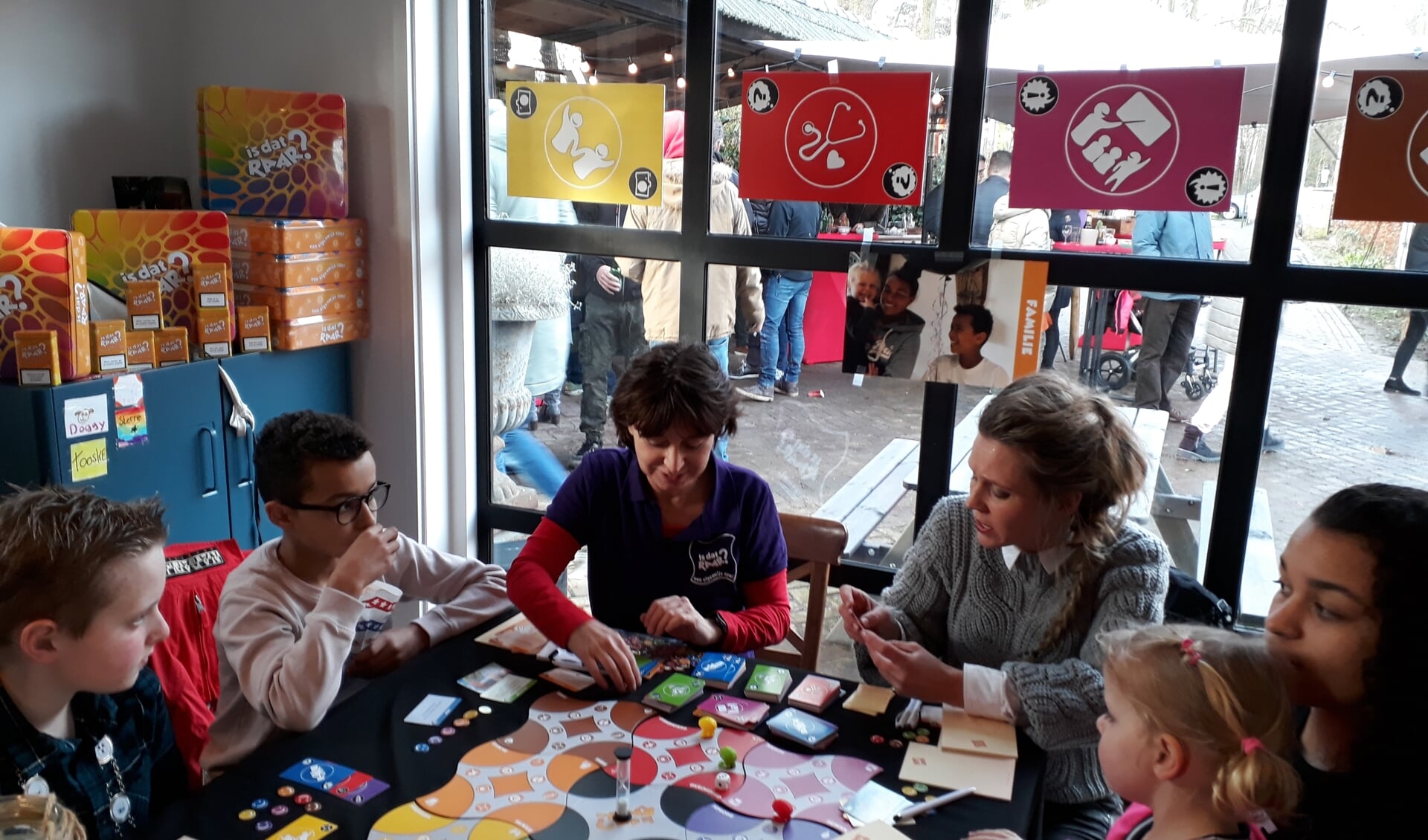 Kjeld, Yassin, Ellen, Patricia en Nisrin met zusje Tirza op schoot (v.l.n.r.). Samen spelen zij de kinderversie van het bordspel. Foto: Ceciel Bremer