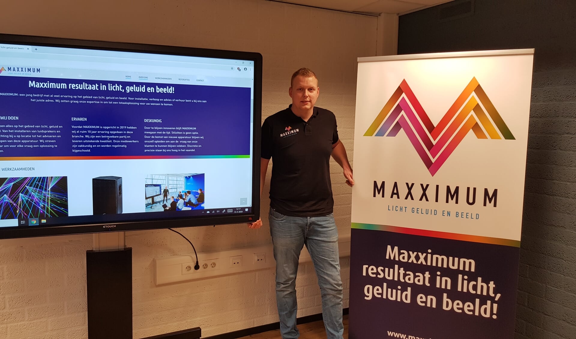 Max Waaijman tussen de CTOUCH Digitale Touchscreen en de banner van Maxximum 