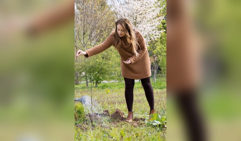 Anne Wieggers strooit bollen uit in de tuin. Foto: Bijen Educatie Stichting Nederland