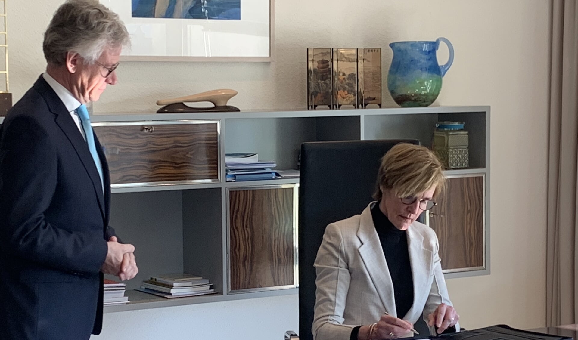 Onder toeziend oog (en op gepaste afstand) van Commissaris van de Koning John Berends, ondertekent Annette Bronsvoort haar herbenoeming tot burgemeester van Oost Gelre.