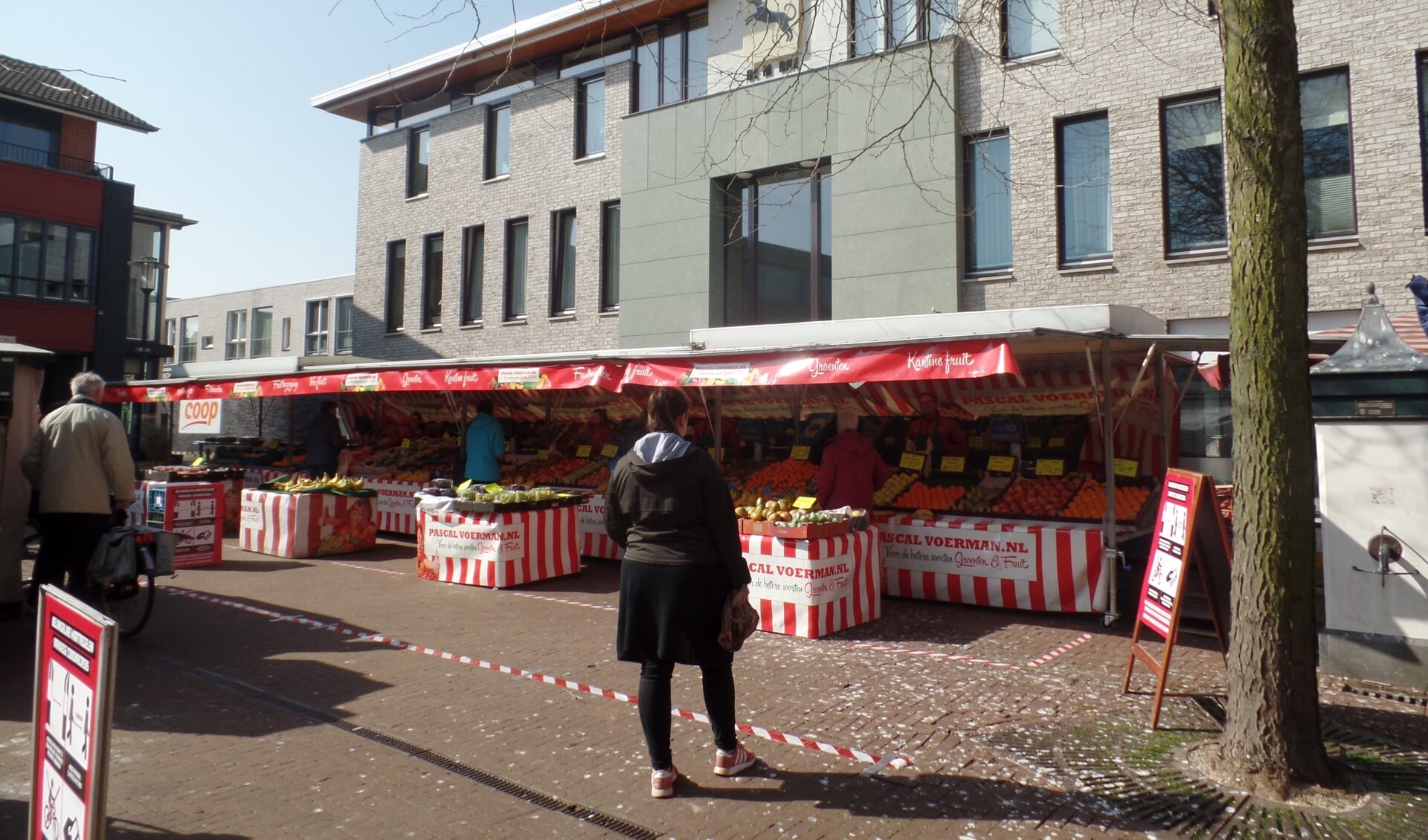 Enkele marktondernemers hadden met rood-witte linten vakken gemaakt voor hun verkoopkraam zodat de marktbezoekers voldoende afstand konden houden. Foto: Jan Hendriksen. 