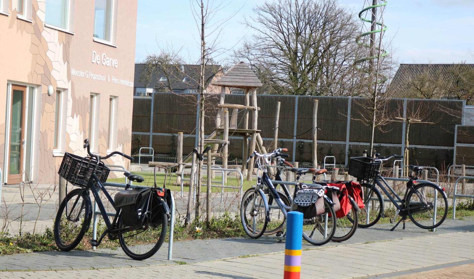 Lege speeltoestellen en enkele fietsen van de leraren bij school. Foto: Arjen Dieperink