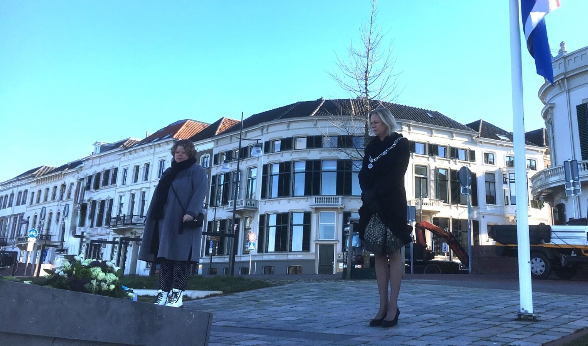 Burgemeester en directeur de Bongerd leggen bloemen bij monument op IJsselkade. Foto: PR