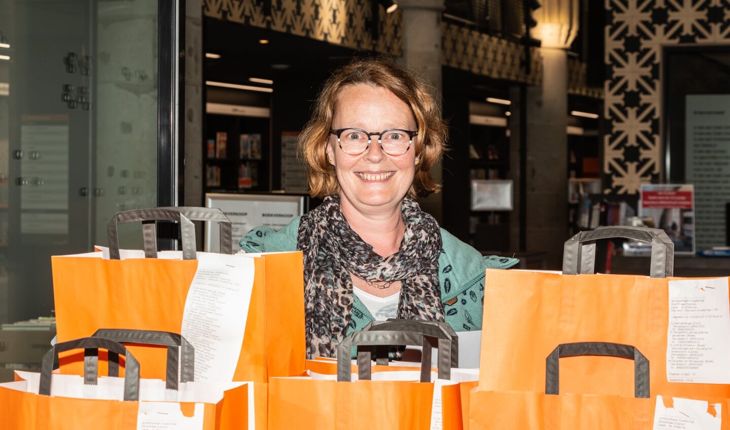 Bibliotheekmedewerkster bij de tassen met af te halen boeken. Foto: Henk Derksen