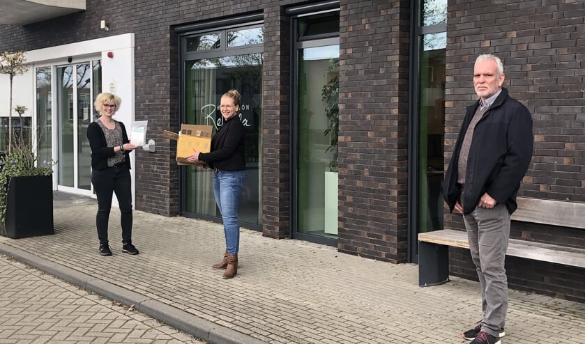 De mondkapjes worden door Petra Kastein en Henk Haaring overhandigd aan Dagmar Schenk. Foto: PR