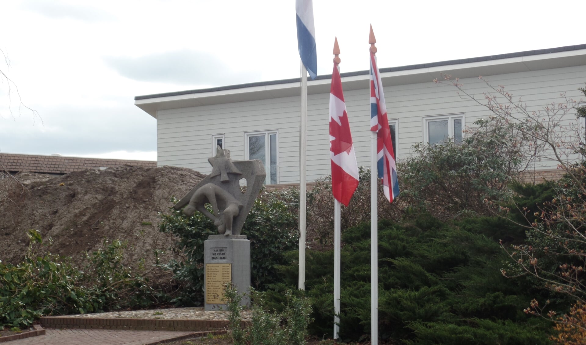 Naast de nationale vlag waren ook de Engelse en Canadese vlag bij het oorlogsmonument geplaatst. Foto: Jan Hendriksen. 