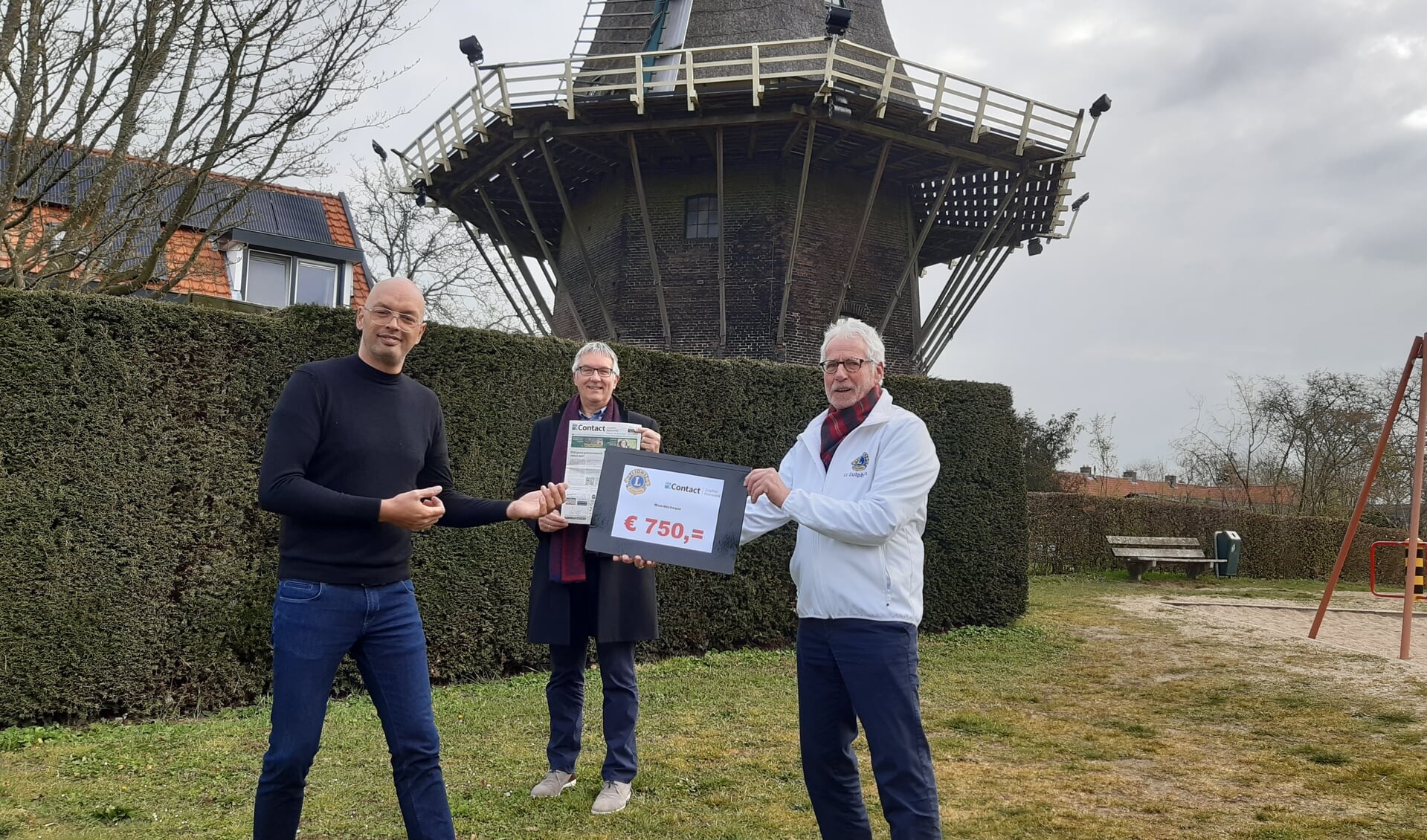 Rick Lesnussa (l) van weekblad Contact neemt de waarde cheque van 750 euro in ontvangst van Lionspresident Paul van Haandel (rechts) en Henk Derksen. Foto: PR