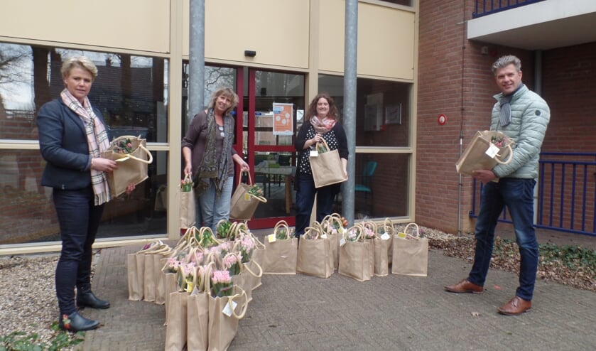 Carmen Rondeel (l) en Peter Besselink (r) van de Vordense Ondernemers Vereniging overhandigen de medewerkster van Sensire Hackforterhof de verrassingstasjes. Foto: Jan Hendriksen