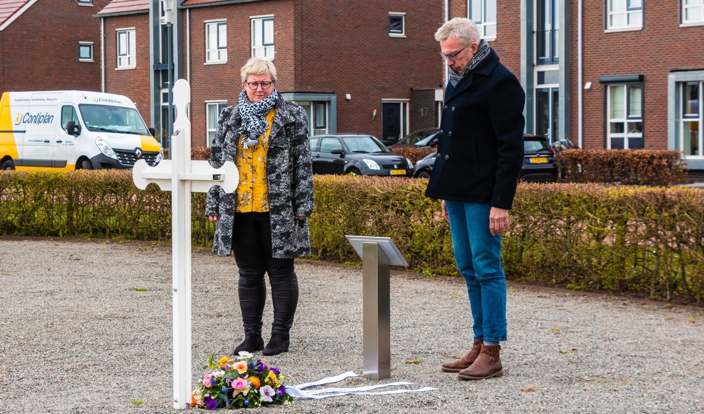 Helmi Jansen en Dick Teunissen herdenken een ogenblik in stilte nadat zij het bloemstuk bij het Witte Kruisje hebben gelegd. Foto: Henk Derksen