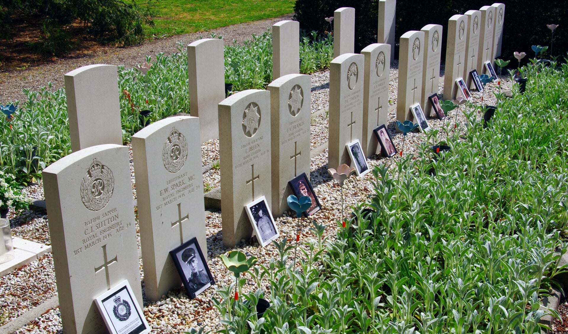 De bij de graven geplaatste foto's geven de gesneuvelden een gezicht.  Foto: Ron van Dijk