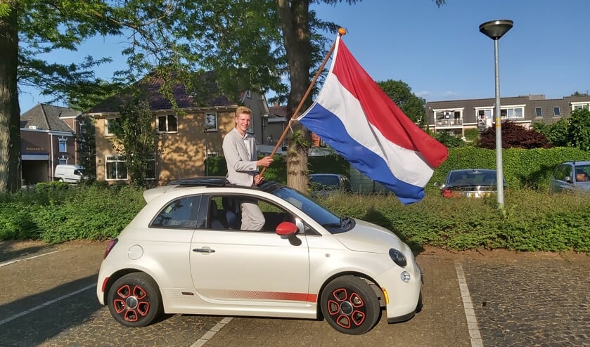 Teun Elburg viert alvast even zijn diploma, in zijn galakostuum en met de fraaie cabrio die hem normaal gesproken naar het gala zou brengen. Foto: Familie Elburg