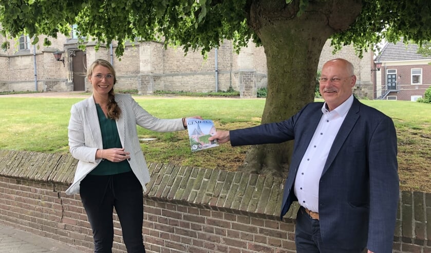 Herlinda ter Maat reikt de gids uit aan wethouder Martin Veldhuizen. Foto: PR