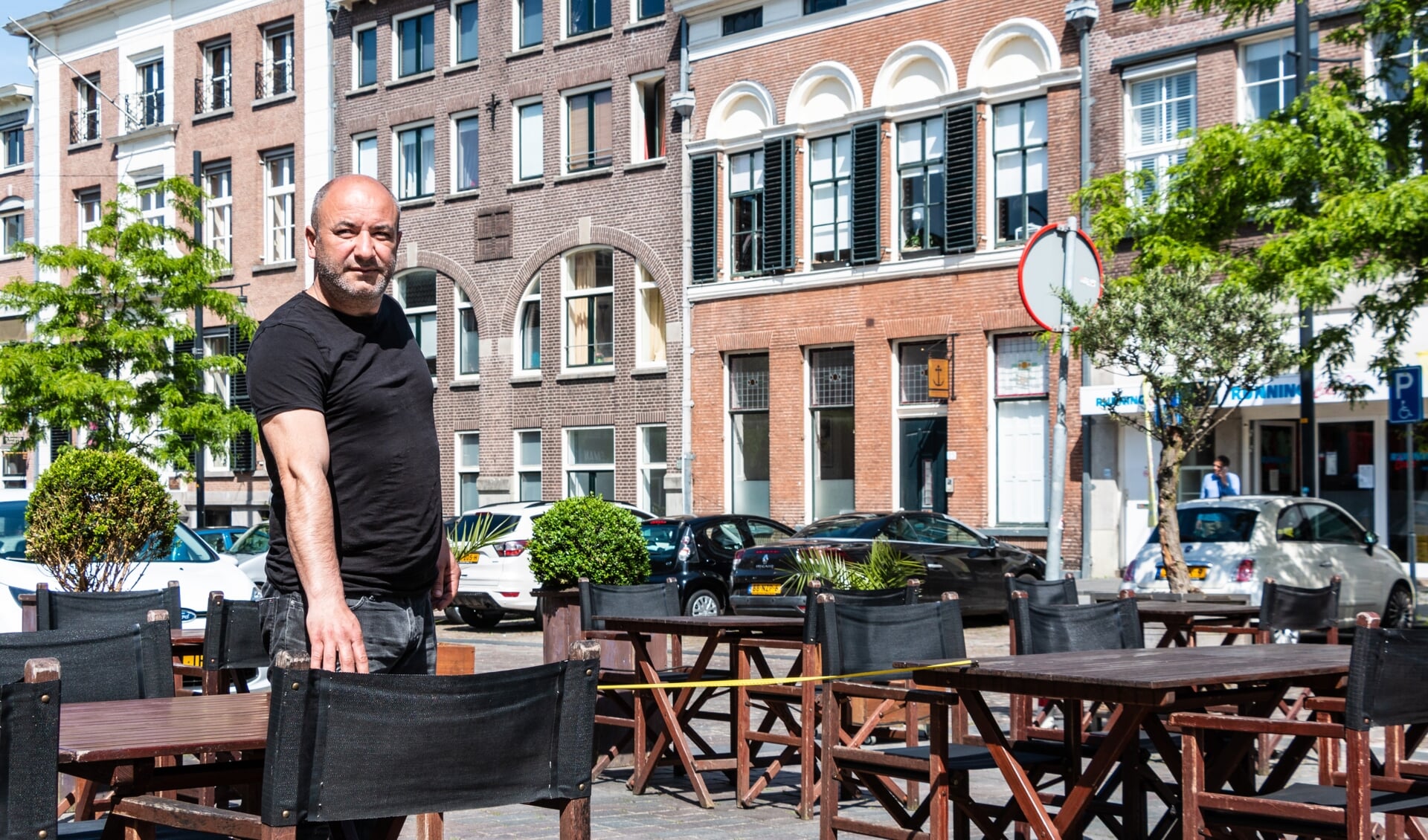 De heer Kavak van Restaurant Rocca controleert de afstand tussen de tafeltjes met een meetlint. Foto: Henk Derksen