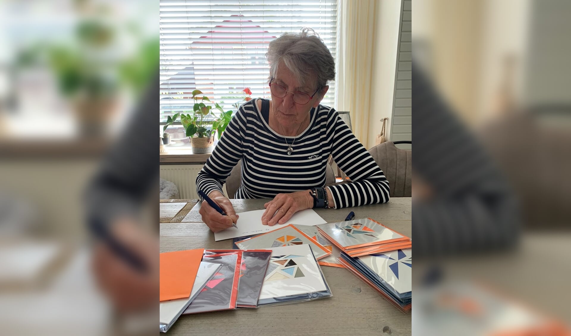 Present vrijwilliger Yvonne druk bezig met het schrijven van kaarten. Foto: Present Winterswijk