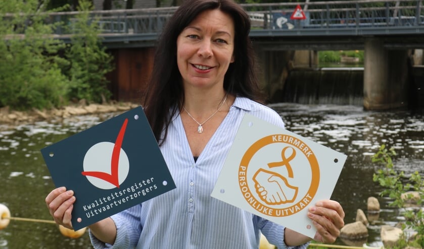Ester Dolphijn met de borden keurmerk Persoonlijke Uitvaart en Kwaliteitsregister Uitvaartverzorgers. Foto: Arjen Dieperink