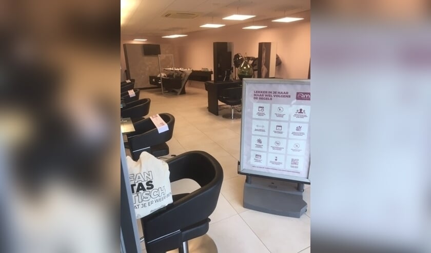 De helft van de stoelen is afgeplakt en het bord geeft de huidige regels in de kapsalon aan. Foto: PR