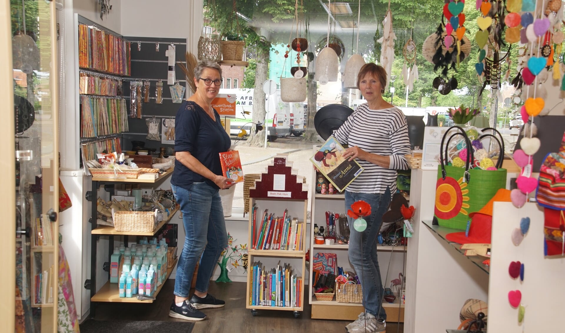 Medewerkers van de Wereldwinkel bij het Zwerfboekenkastje. Foto: Frank Vinkenvleugel