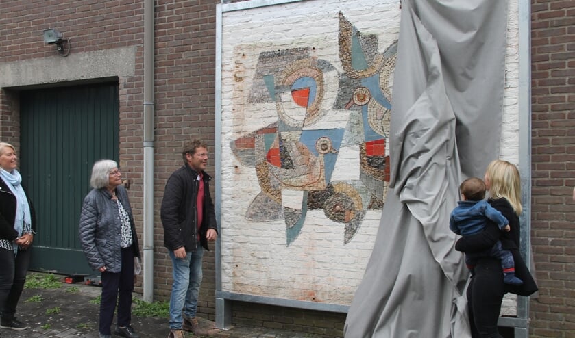 'Jenni, Minie, en Jan Derk Heesen (vlnr) kijken toe hoe hun (klein)dochter met haar zoon het mozaïek van Ger Heesen onthult. foto Lineke Voltman