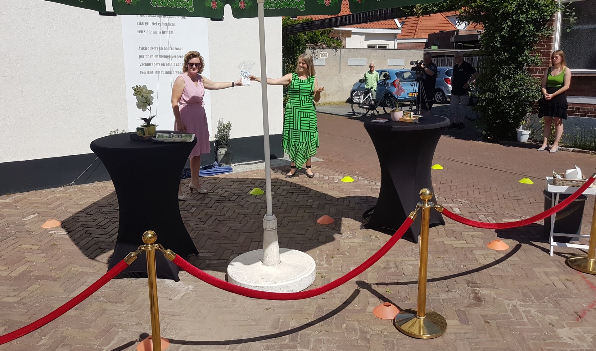 Meike Pollius reikt de eerste muurgedichtenroute uit aan wethouder Marieke Frank. Foto: Mark Ebbers