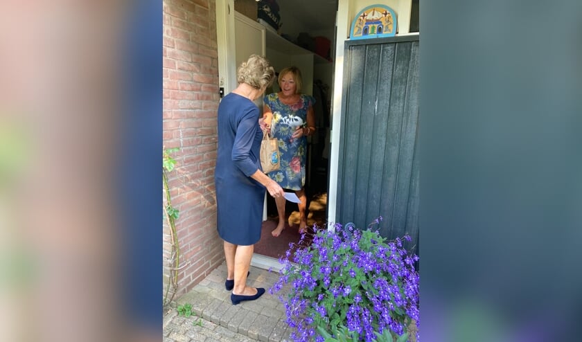 Bestuurslid Anne-Mieke Jansen op de Haar van Stichting Welzijn Vorden overhandigt een van de vrijwilligers een tas met fruit. Foto: PR.