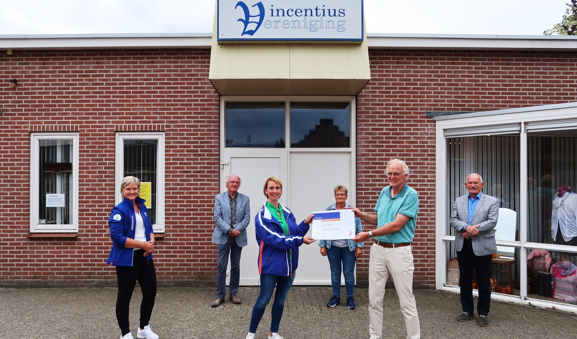 Gerard Kamp, voorzitter van de Vincentiusvereniging, neemt de Rabo-cheque in ontvangst van Marrit Heuzinkveld, terwijl Petra ter Bogt (geheel links) toekijkt. Foto: Theo Huijskes