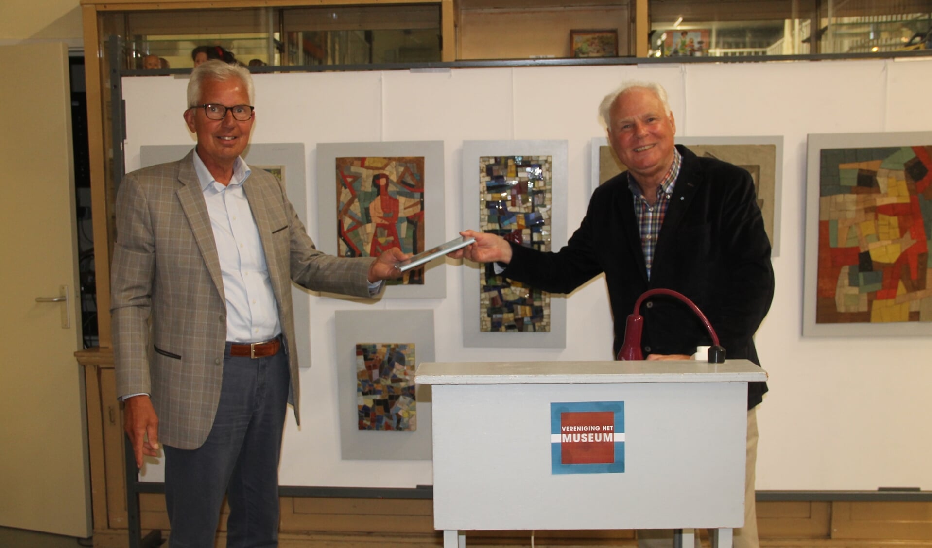 Hans van Lith (r) reikt het 1000ste exemplaar van 'Mijn jeugd in oorlogstijd' uit aan Thijs van Beem (l).  Foto Lineke Voltman