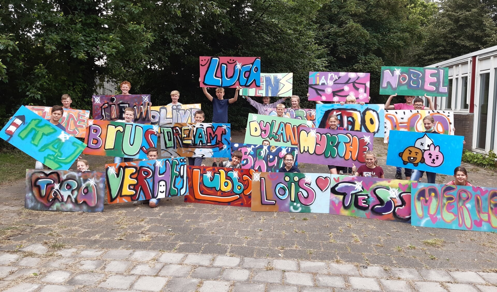 De achtstegroepers van Het Simmelink met het resultaat van de workshop graffiti. Foto: Marloes ten Bras