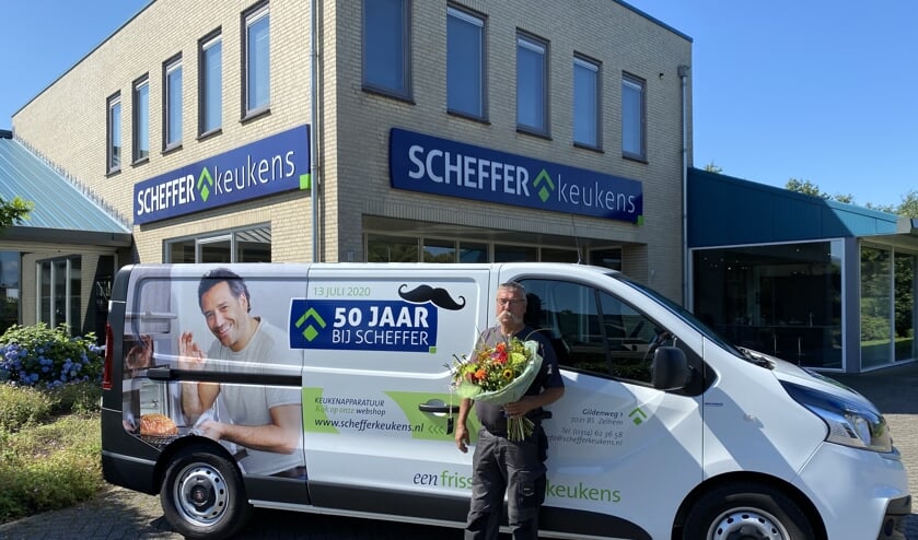 Jubilaris Bennie Massen ‘poseert’ met een bos bloemen voor zijn bus, die voor dit jubileum wat aangepast is. Foto: PR