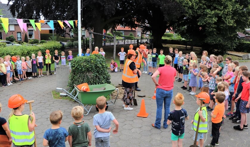 Directeur Dicky ter Beek samen met 'Opa Harrie' omringd door de kinderen van de Antoniusschool tijdens de aftrap van het groene schoolplein-project. Foto: Antoniusschool Vragender
