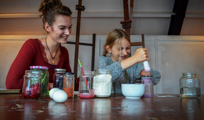 Fenna Houtman maakt zelf verf van natuurlijke materialen onder toeziend oog van Jolien Visser. Foto: Miranda Visser.