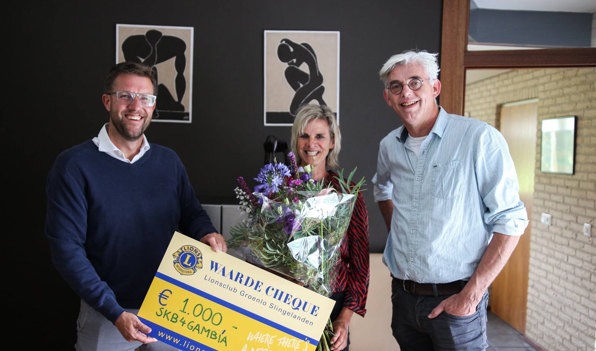 Carla Klein Breteler van SKB4Gambia (midden) krijgt de cheque behorend bij de Lions Award uitgereikt door president Maarten Reimes (links) en lid Theo Helmers (rechts) van de Lionsclub Groenlo-Slingelanden.