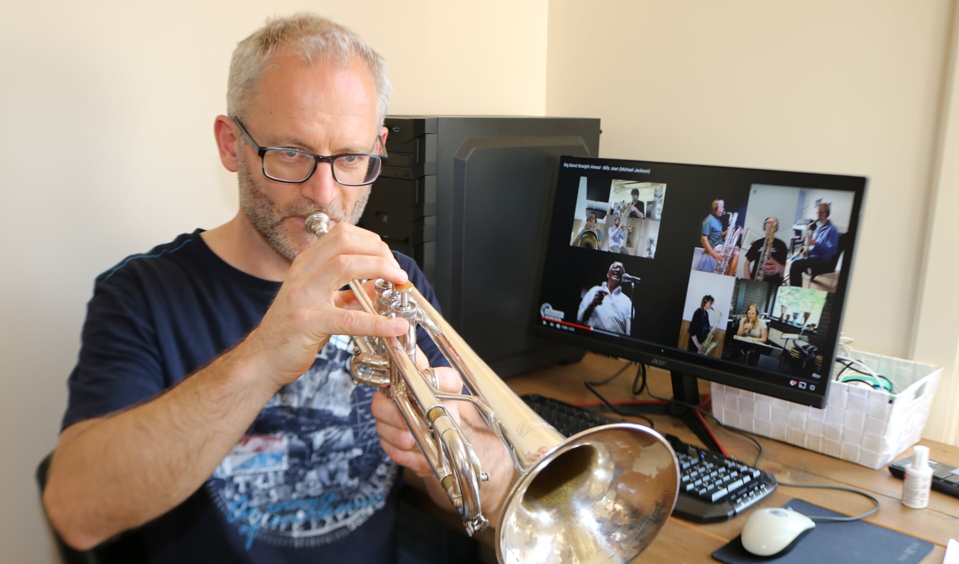 Terwijl op het beeldscherm zijn band speelt, pakt Sander Zweerink zijn trompet. Foto: Arjen Dieperink