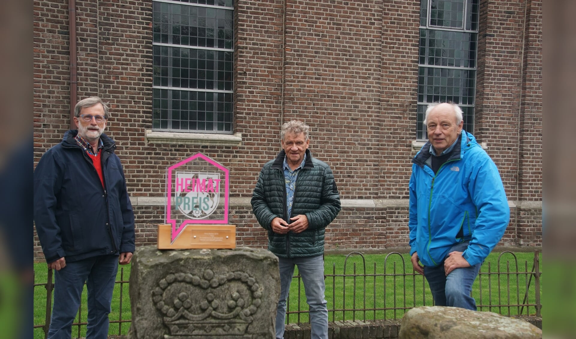 Van links af Werner Brand, Freek Diersen en Johannes Hoven, bij de St. Michaelskirche, op de plek waar de prijsuitreiking zal plaatsvinden.  Foto: Frank Vinkenvleugel