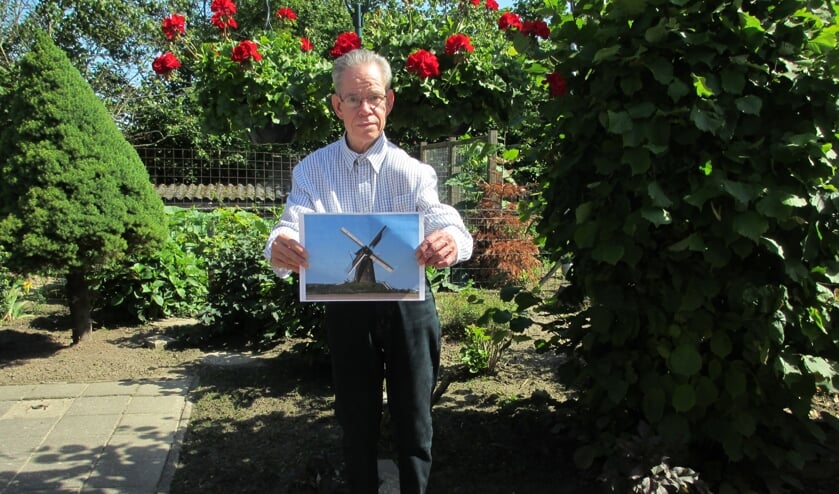 Wim Knaake met een foto van zijn favoriete plek in Bronkhorst: de molen. “Vroeger met Pasen gingen we daar eieren rollen. Dan klommen we bovenop de molenbult en rolden we eieren naar beneden.” Foto: J.E. Aalderink-Wolters.