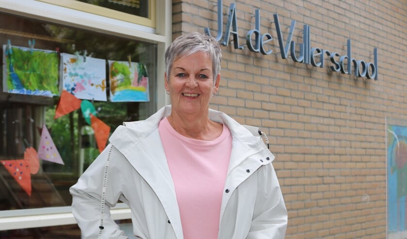 Juf Trudy, voor het raam van haar klaslokaal, neemt vrijdag afscheid. Foto: Arjen Dieperink
