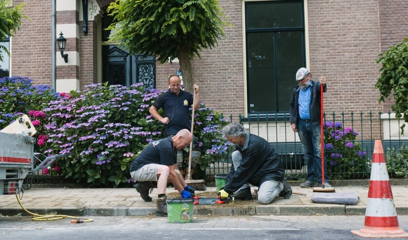 Eén van de tegels wordt gelegd door Henk Greven (l) en Harold Pelgrom. Op de achtergrond Joey Mullink en Harry Jansen. Frank Sessink ontbreekt op de foto. Foto: Anka Pelgrom
