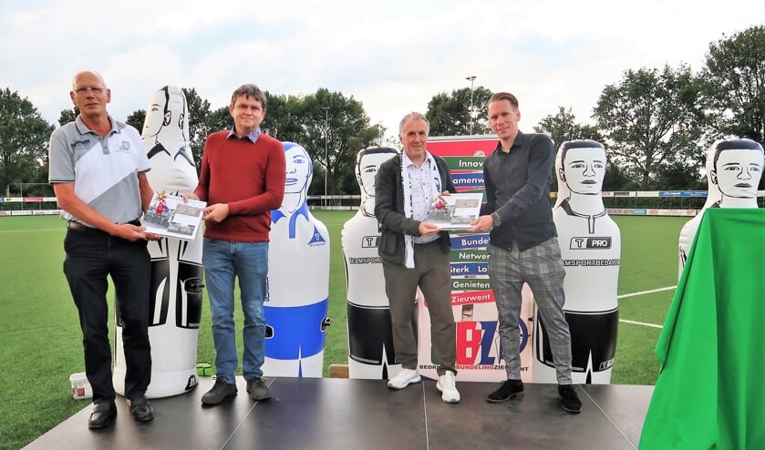 De overhandiging van het jubileumboek aan voorzitter Johnny Cuppers door Bennie Storkhorst (links) en aan trainer Laurens Knippenborg door Sjors Storkhorst (rechts). Foto: Theo Huijskes