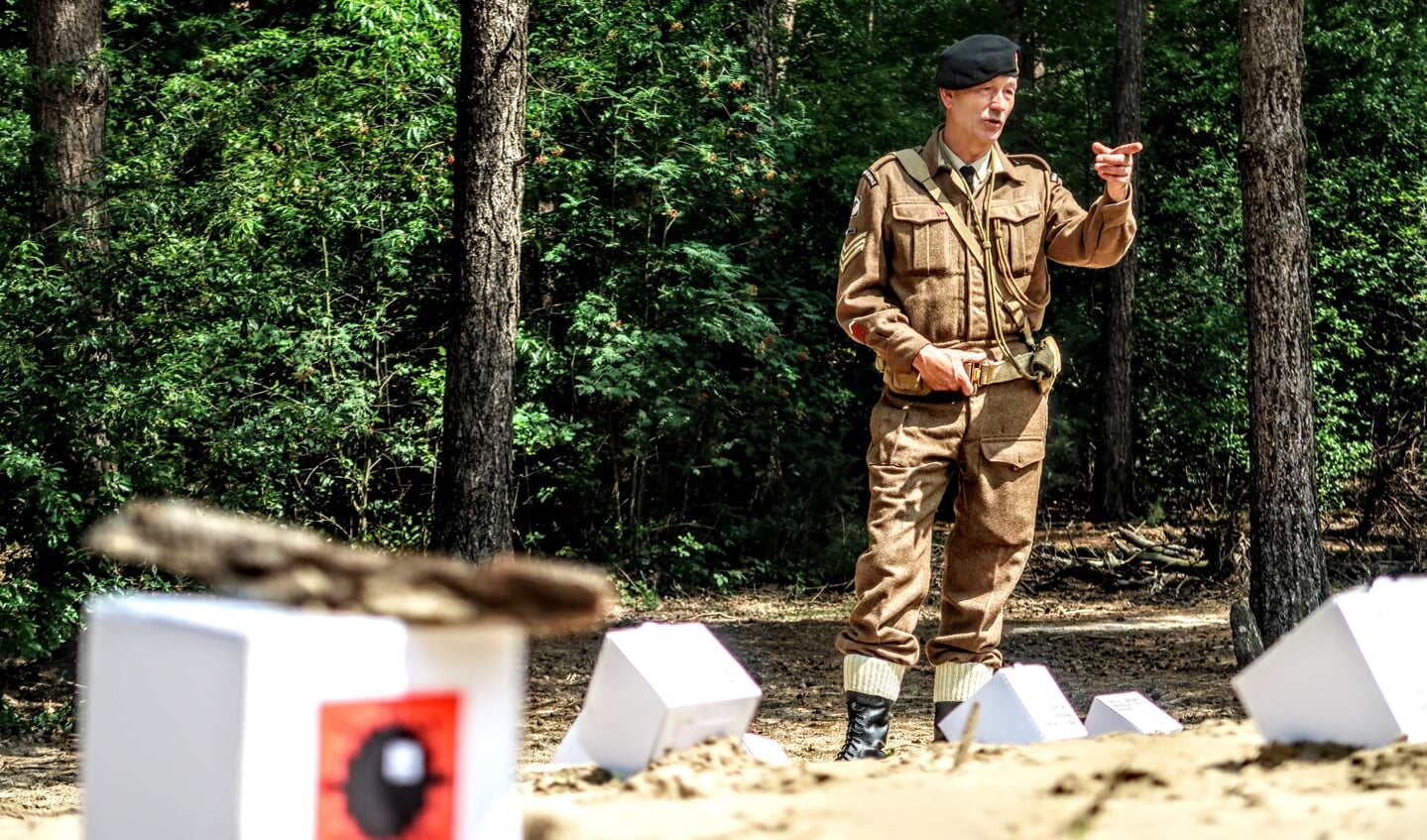 Gerrit Bruggink – gekleed in het uniform van het Britse Royal Corps of Signals – legt uit waar volgens hem de bommen zijn verstopt. Foto: Luuk Stam